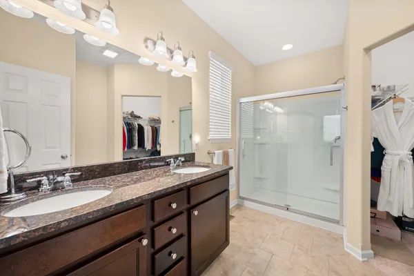 a bathroom with a granite countertop sink a mirror a shower and a bathtub