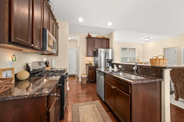 a kitchen with stainless steel appliances granite countertop a sink stove and refrigerator