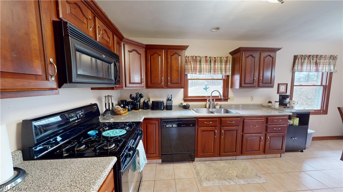 167 Mathews Road, Unit B Youngstown, OH 44512 - Photo 13 of 34 Kitchen featuring black appliances, sink, a wealth of natural light, and light tile floors