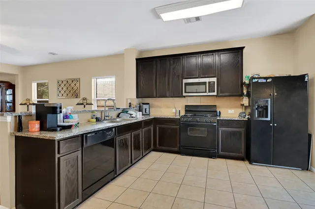a kitchen with stainless steel appliances granite countertop a refrigerator and a stove top oven