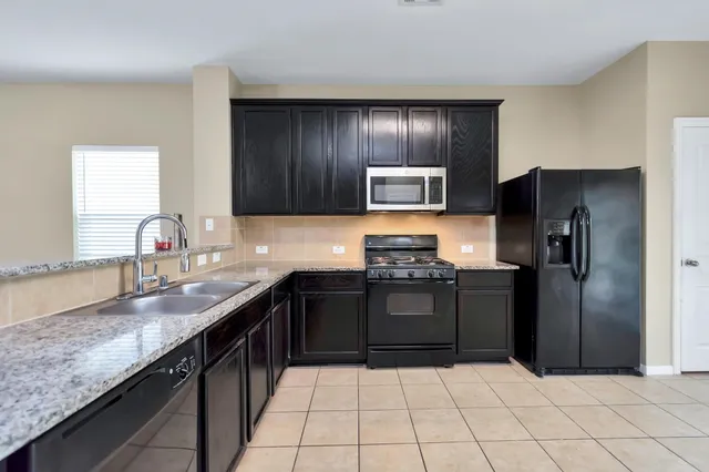 a kitchen with granite countertop stainless steel appliances and a sink