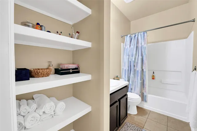 a bathroom with a sink a toilet and shower curtain