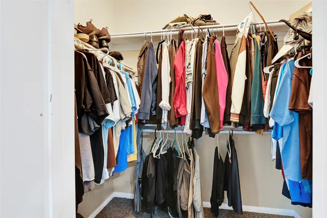 a view of walk in closet with clothes