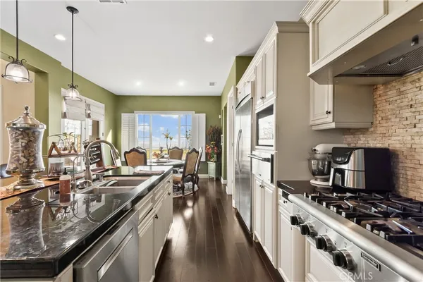 a kitchen with white cabinets and appliances