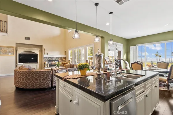 a kitchen with stainless steel appliances a dining table chairs and a refrigerator