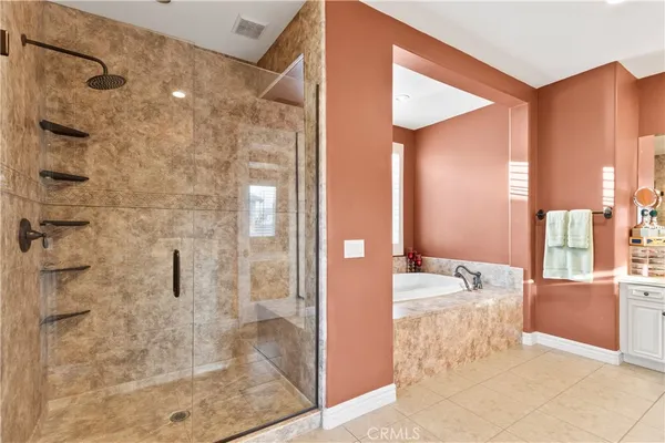 a large bedroom with a large bed a flat tv screen and dresser