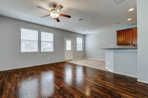a view of an empty room with window and wooden floor