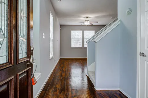 a view of a hallway with wooden floor and staircase