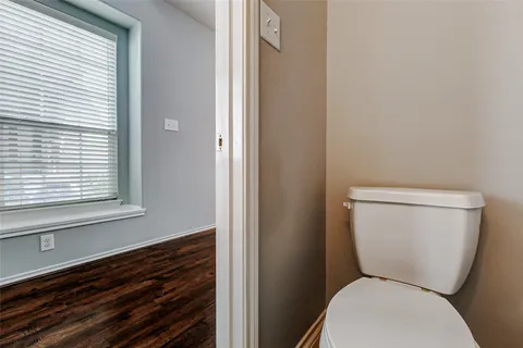 a white toilet sitting next to a window