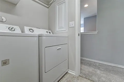 a view of an empty room and chandelier fan