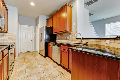a kitchen with stainless steel appliances granite countertop a refrigerator and a stove