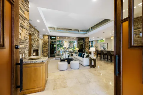 a living room with furniture a fireplace and a chandelier