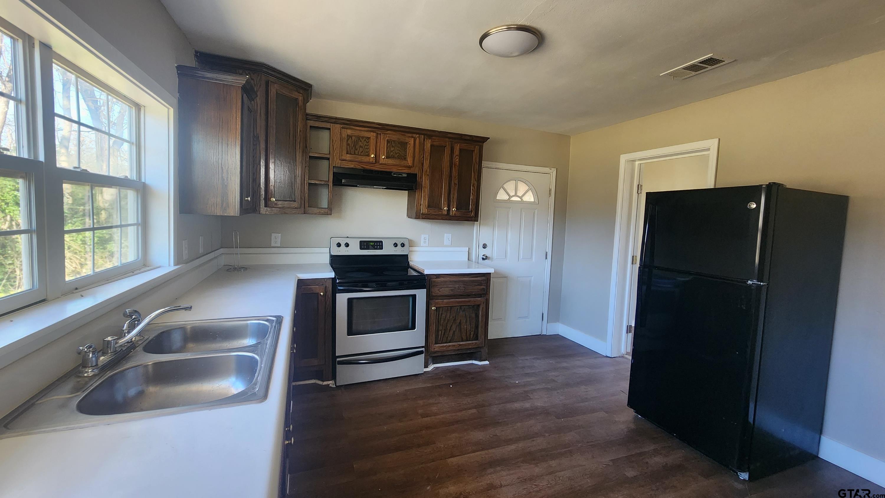 104 Carson Street Pittsburg, TX 75686 - Photo 2 of 9 a kitchen with a refrigerator and a sink