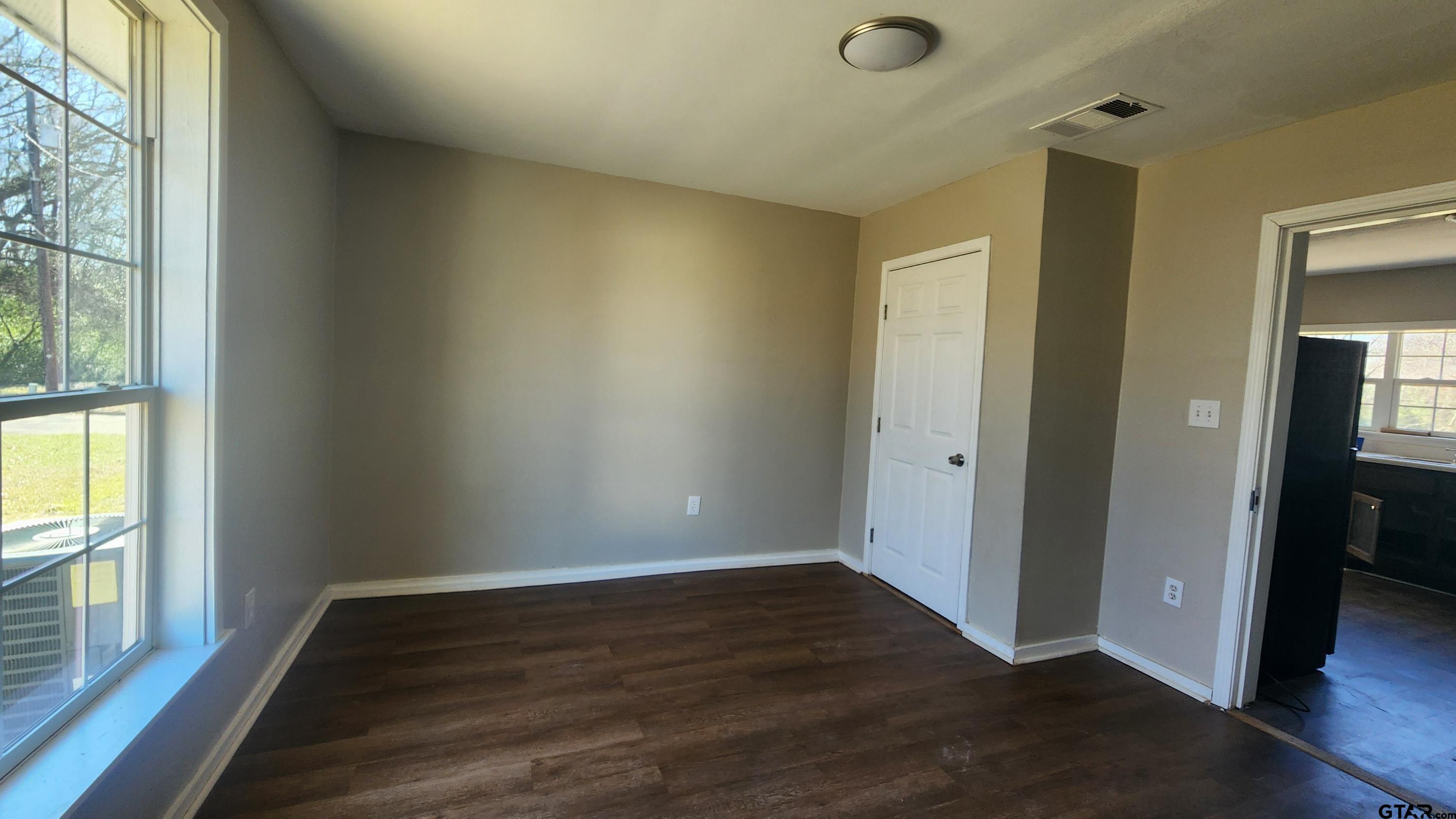 104 Carson Street Pittsburg, TX 75686 - Photo 6 of 9 wooden floor in an empty room with a window