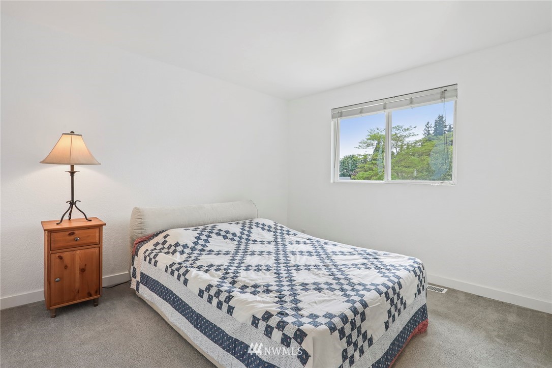 19230 90th Place Northeast Bothell, WA 98011 - Photo 16 of 40 a bedroom with a bed and a lamp on dresser