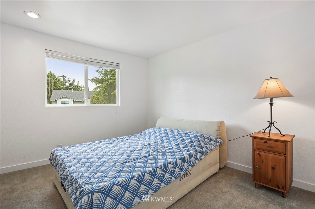 19230 90th Place Northeast Bothell, WA 98011 - Photo 17 of 40 a bedroom with a bed and a chandelier