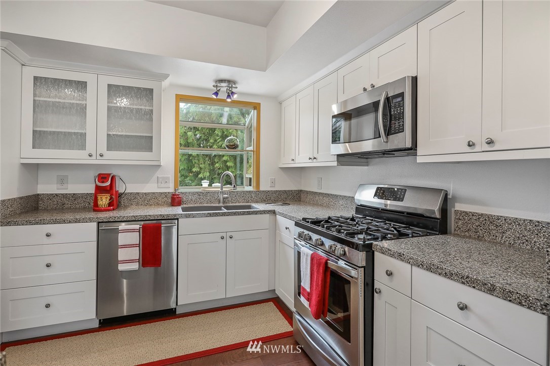 19230 90th Place Northeast Bothell, WA 98011 - Photo 4 of 40 a kitchen with stainless steel appliances granite countertop a stove a sink and a microwave