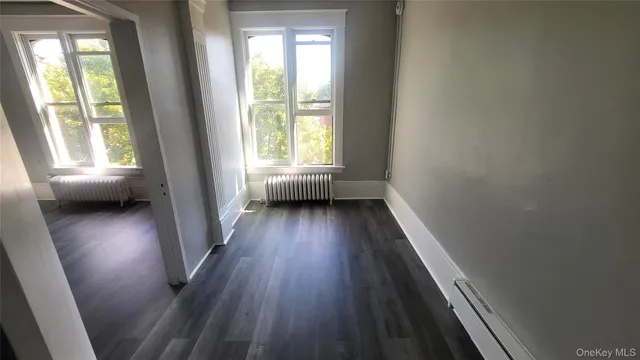 a view of hallway with wooden floor and window