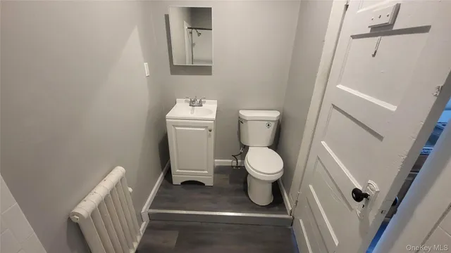 a white toilet sitting next to a white sink and vanity