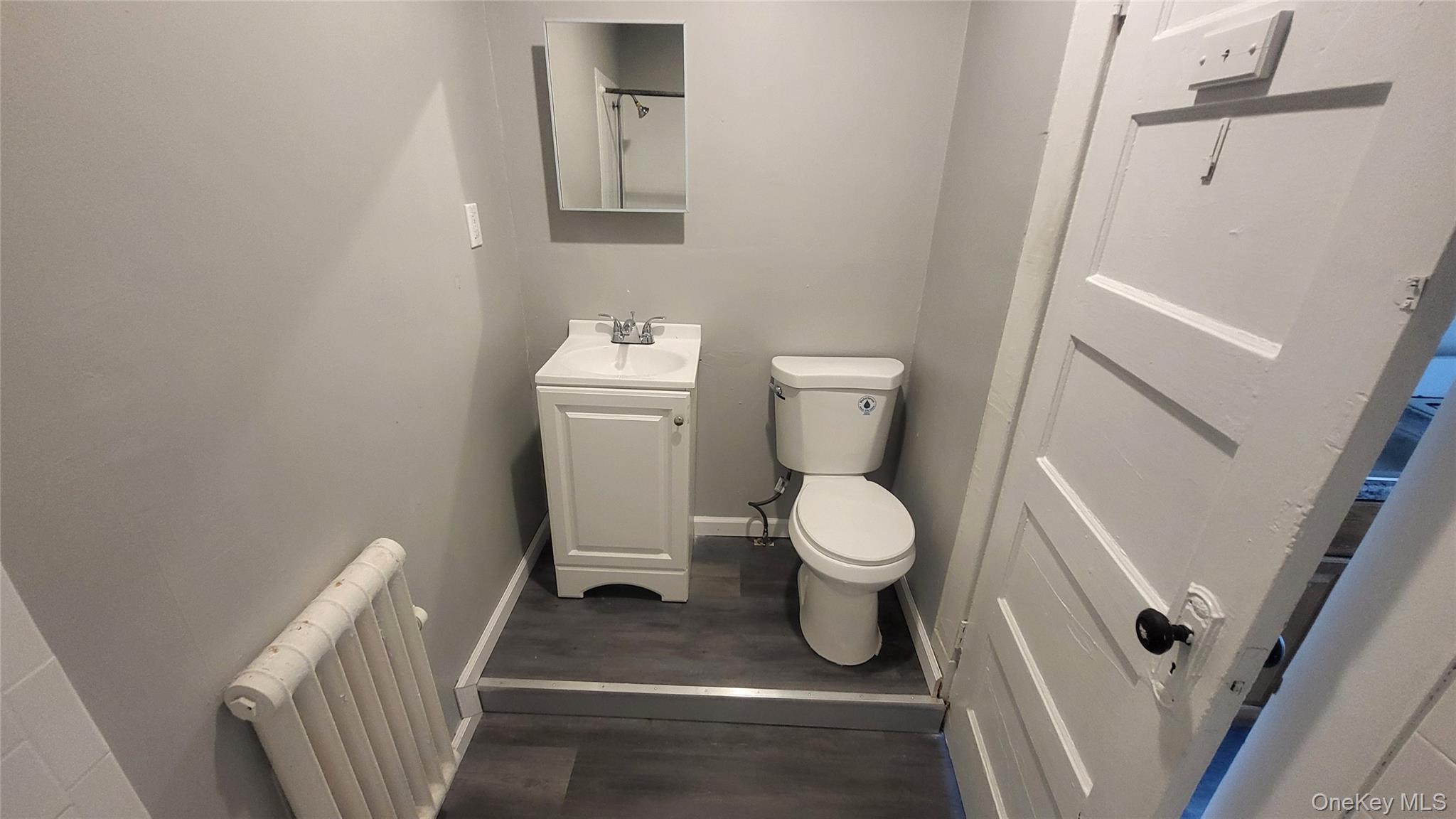 65 South Hamilton Street, Unit 9 Poughkeepsie, NY 12601 - Photo 16 of 20 a white toilet sitting next to a white sink and vanity