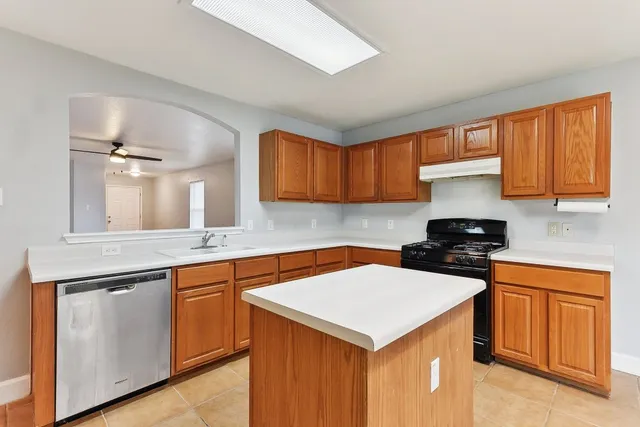 a kitchen with a sink a stove cabinets and a window