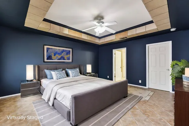 a bedroom with a large bed and a chandelier