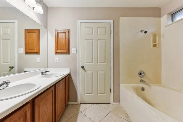 a bathroom with a tub a sink and a mirror