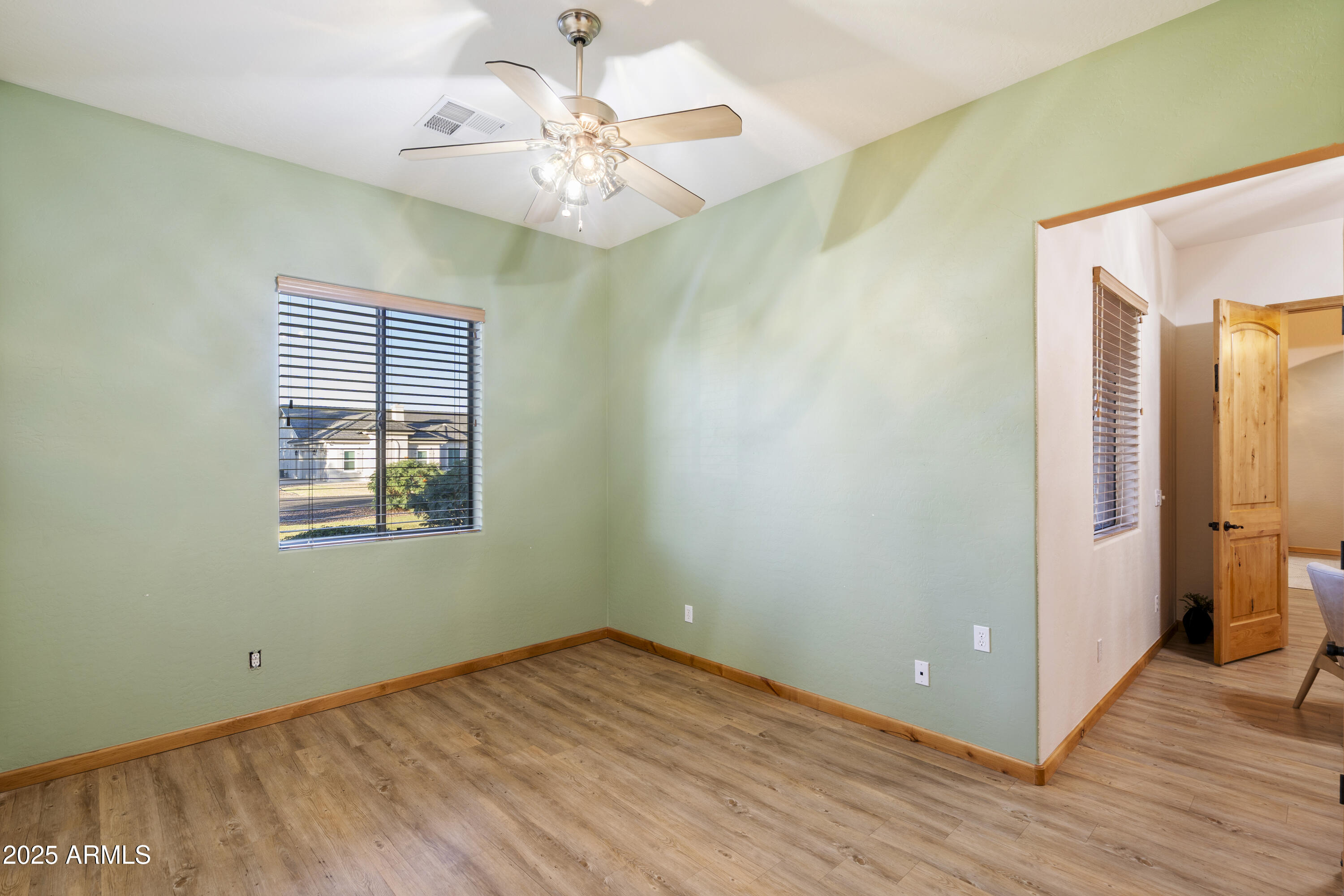 2667 East Melrose Street Gilbert, AZ 85297 - Photo 18 of 32 a view of an empty room with wooden floor and a window