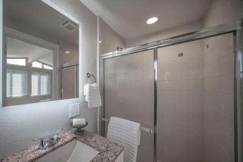 a bathroom with a granite countertop sink a toilet and shower