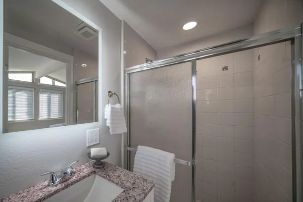 a bathroom with a granite countertop sink a toilet and shower