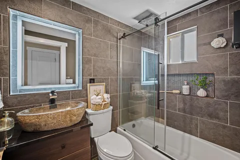 a bathroom with a granite countertop sink toilet and shower