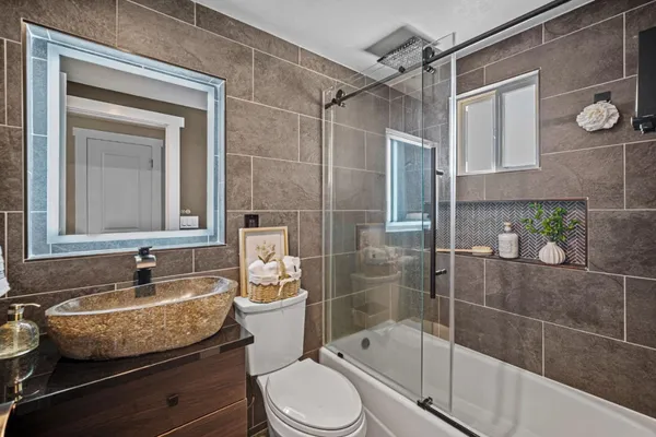 a bathroom with a granite countertop sink toilet and shower