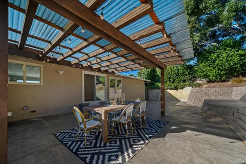 a view of a backyard with table and chairs with wooden floor and fence