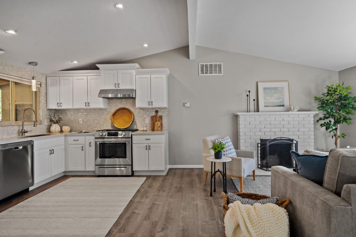 1148 San Lucas Street Seaside, CA 93955 - Photo 5 of 27 a living room with furniture a fireplace a potted plant and a kitchen view