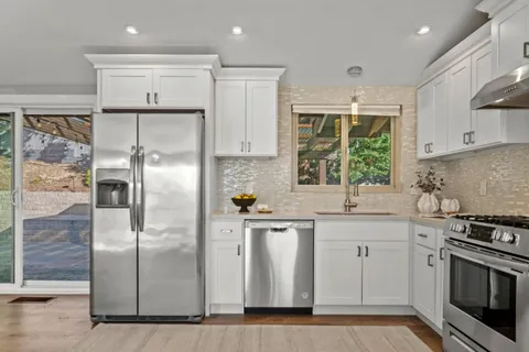 a kitchen with stainless steel appliances a refrigerator sink and stove