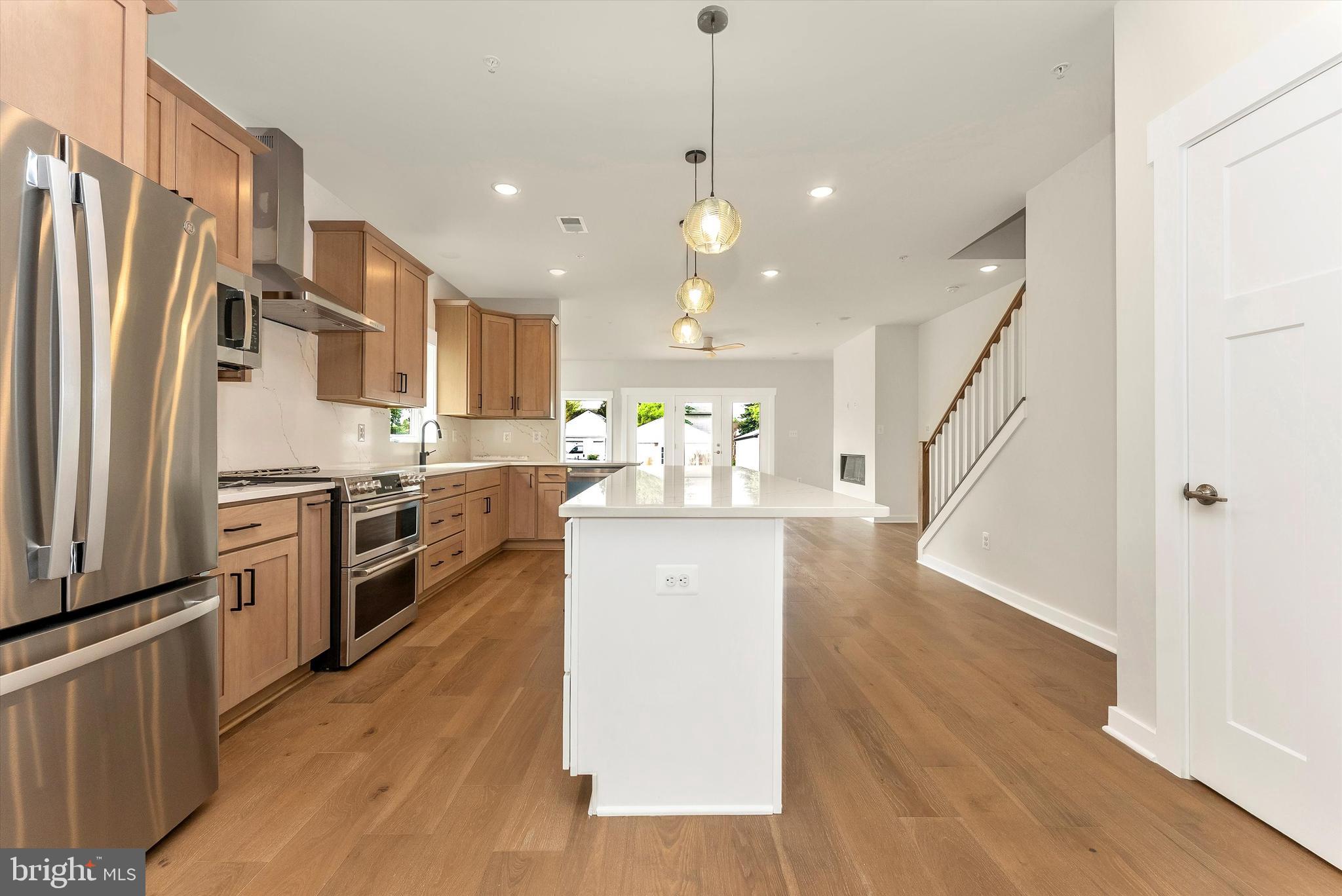 328 Madison Street Frederick, MD 21701 - Photo 12 of 49 a kitchen with stainless steel appliances kitchen island granite countertop a refrigerator a stove a microwave oven a sink with island and chairs
