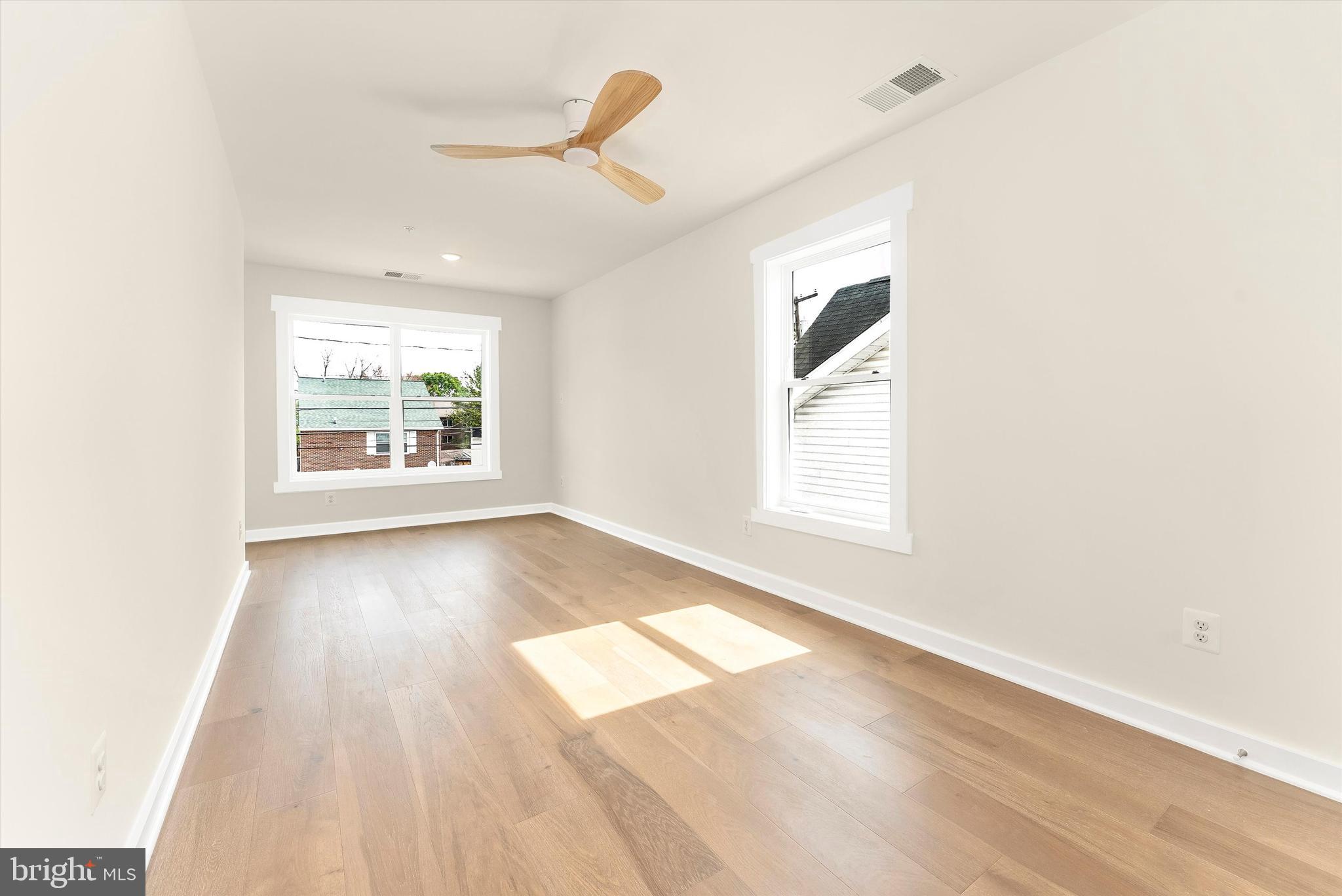 328 Madison Street Frederick, MD 21701 - Photo 32 of 49 an empty room with wooden floor chandelier and windows