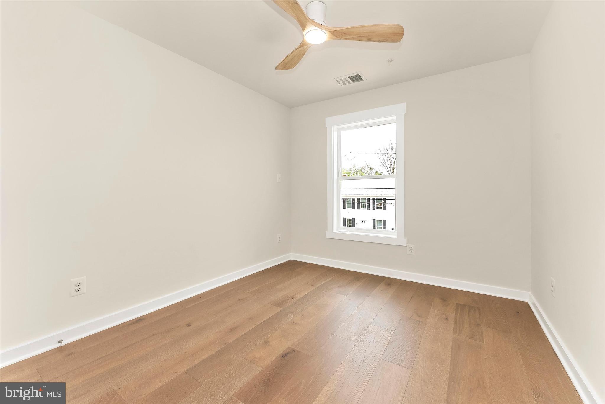 328 Madison Street Frederick, MD 21701 - Photo 34 of 49 an empty room with wooden floor fan and windows