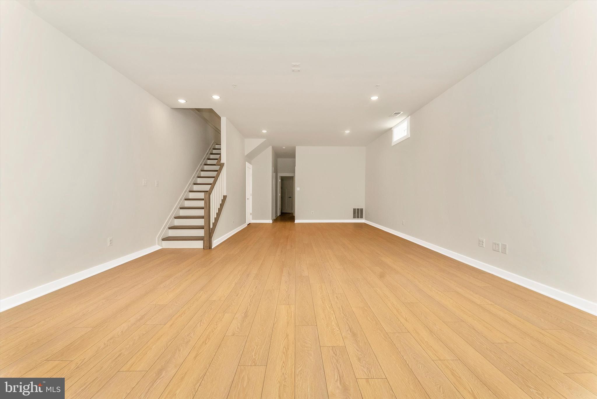328 Madison Street Frederick, MD 21701 - Photo 38 of 49 an empty room with wooden floor and stairs