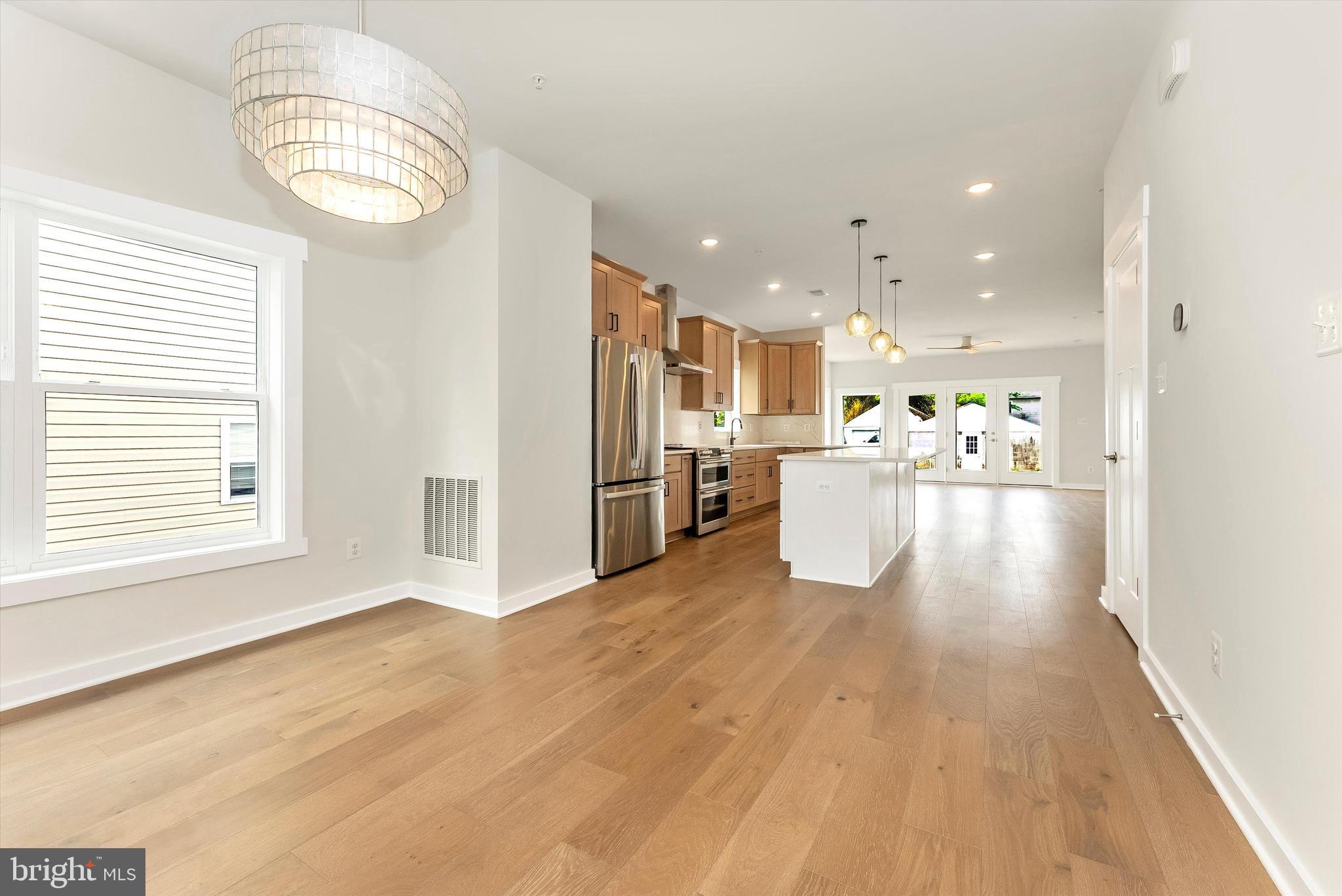 328 Madison Street Frederick, MD 21701 - Photo 7 of 49 a view of a kitchen with kitchen island wooden floors stainless steel appliances and a window