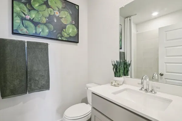 a bathroom with a granite countertop sink a toilet and shower