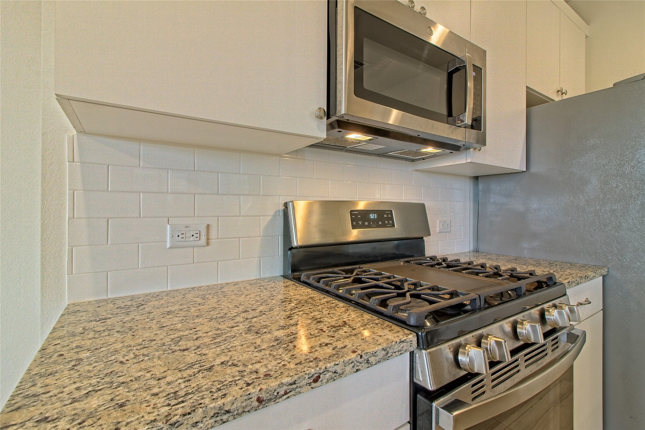 555 White Steppe Way Georgetown, TX 78626 - Photo 17 of 40 a kitchen with stainless steel appliances granite countertop a stove and a microwave