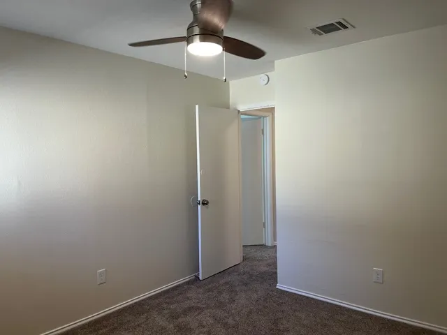 an empty room with a empty space and a ceiling fan
