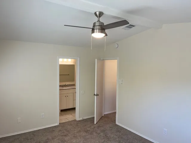 an empty room with chandelier fan