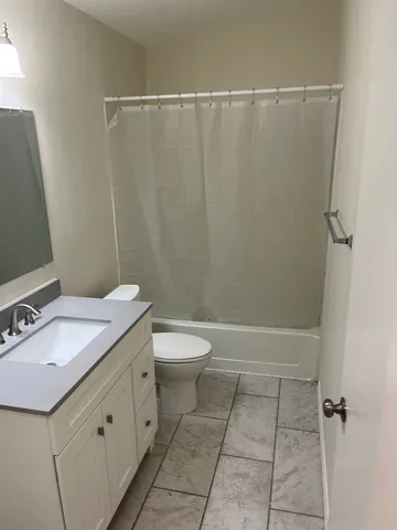 a bathroom with a granite countertop sink toilet and shower