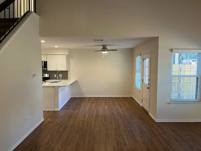 wooden floor in an empty room with a kitchen