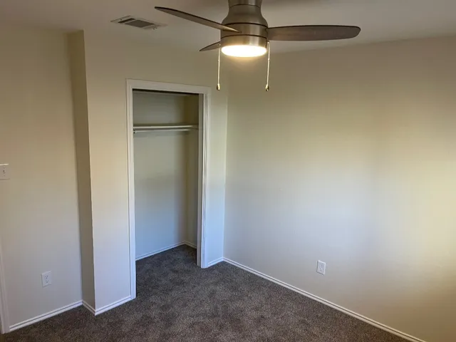 an empty room with closet and windows