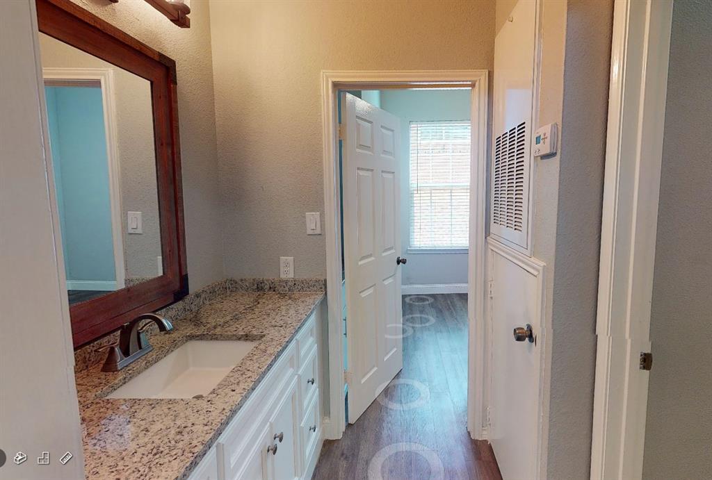 2814 Nueces Street, Unit 103 Austin, TX 78705 - Photo 2 of 7 a bathroom with a granite countertop sink and a mirror