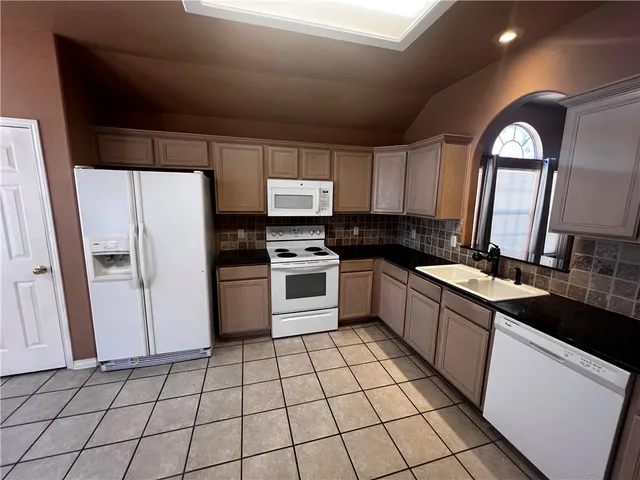 a kitchen with stainless steel appliances a refrigerator sink and cabinets