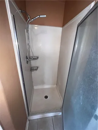 a bathroom with a glass door shower and toilet